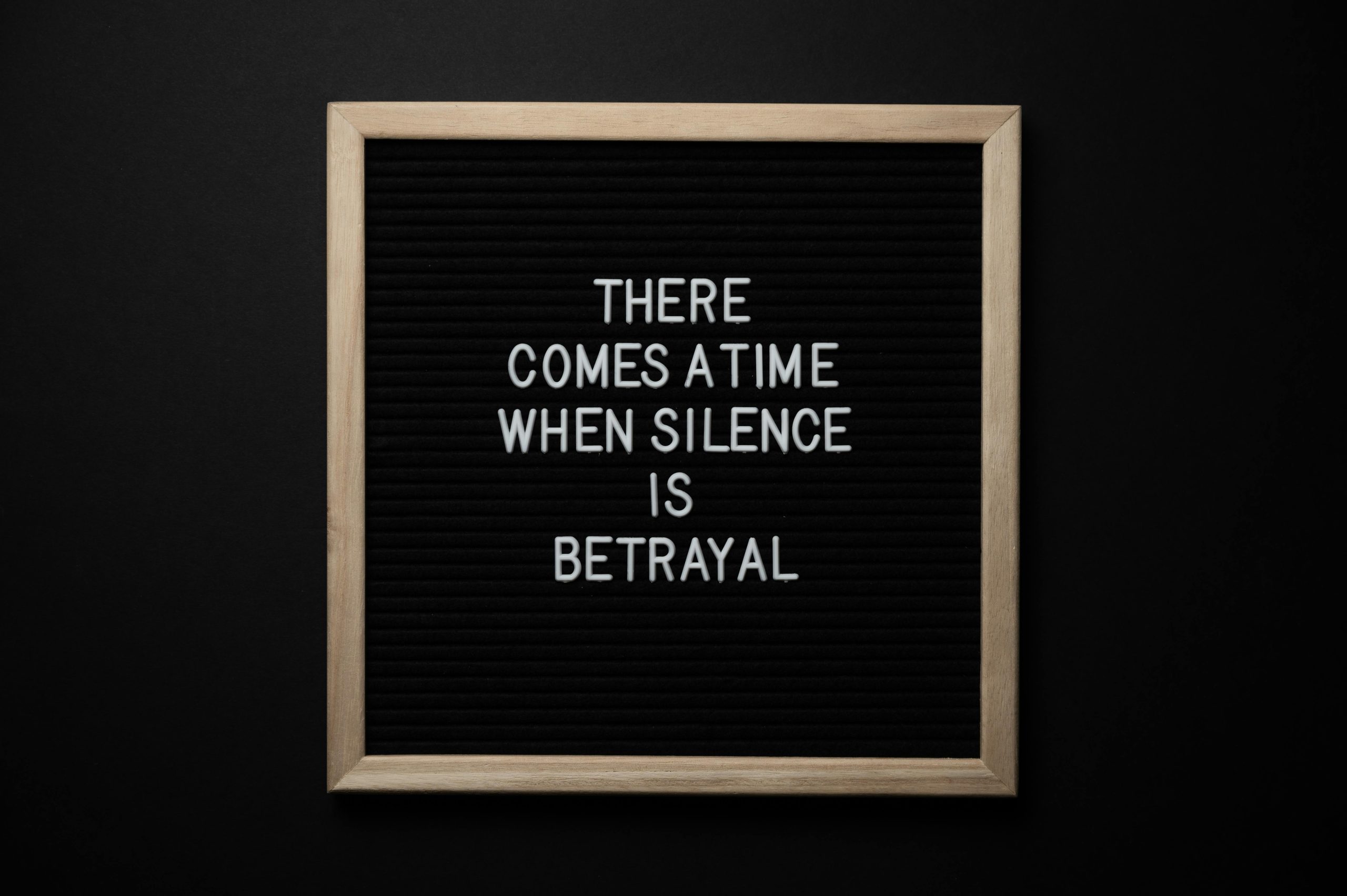 From above chalkboard with THERE COMES A TIME WHEN SILENCE IS BETRAYAL inscription on black background Tableau noir vu d'en haut avec l'inscription "THERE COMES A TIME WHEN SILENCE IS BETRAYAL" sur fond noir