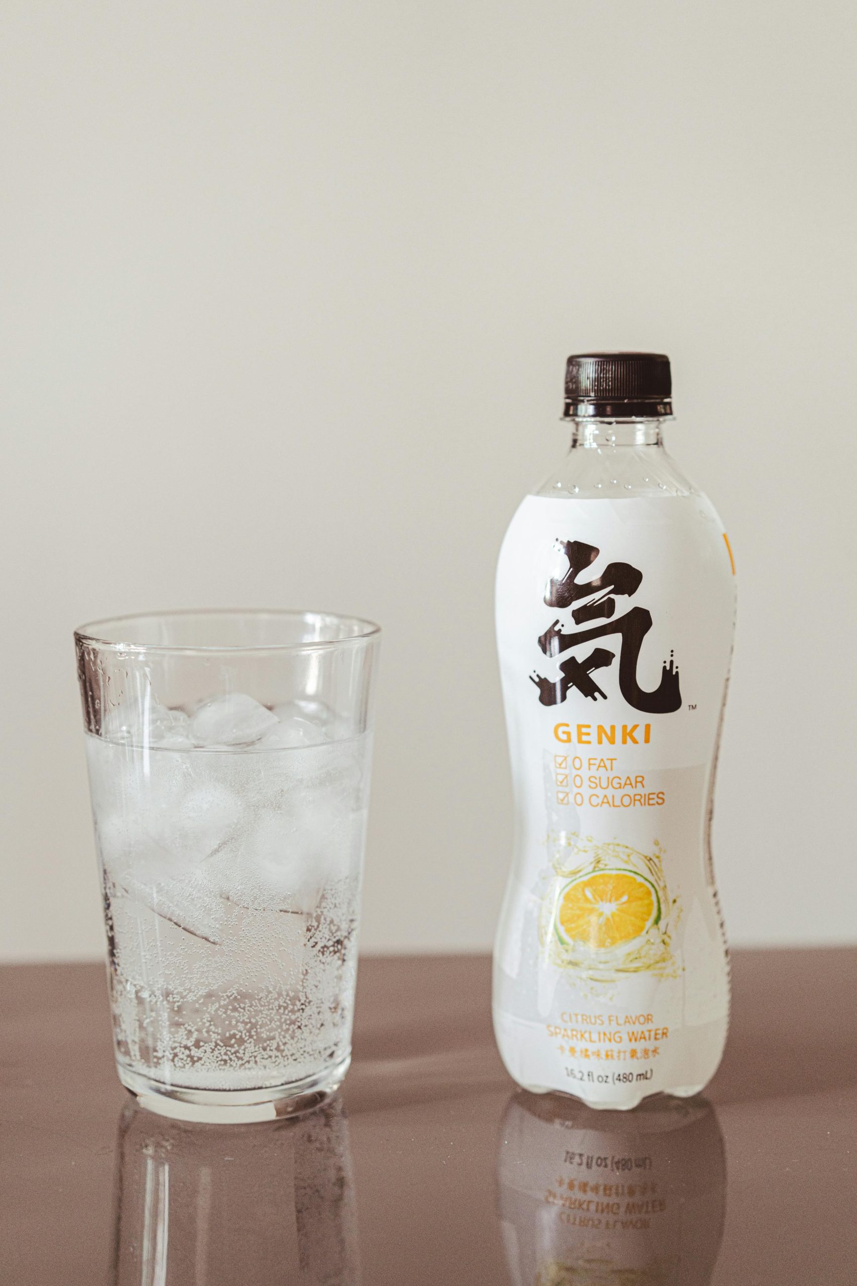 Genki bouteille d'eau pétillante aromatisée au citron avec un verre rempli de glaçons